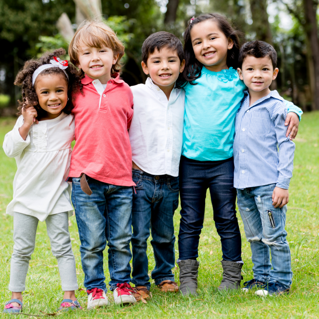 diverse group of young children standing on green grass
