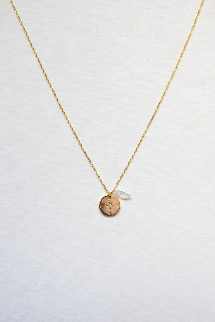 This exquisite necklace features a stunning sterling silver compass adorned with a clear quartz moon shape, symbolizing clarity, direction, and illumination. - gold plated
