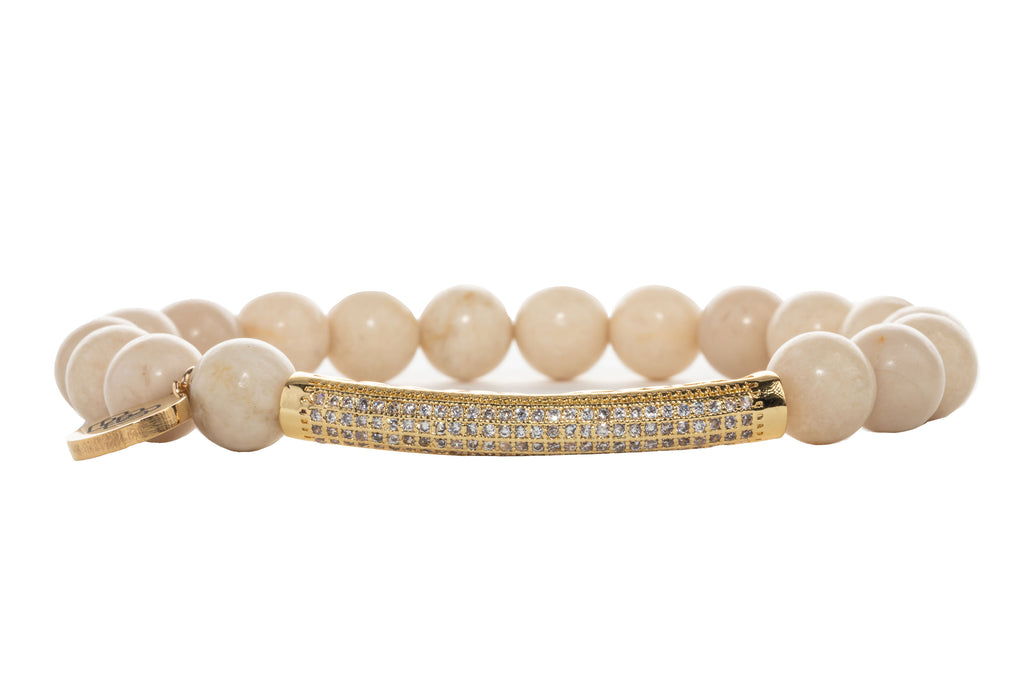 Crafted with 8mm riverstone beige beads, plus a cubic zirconia paved gold connector.