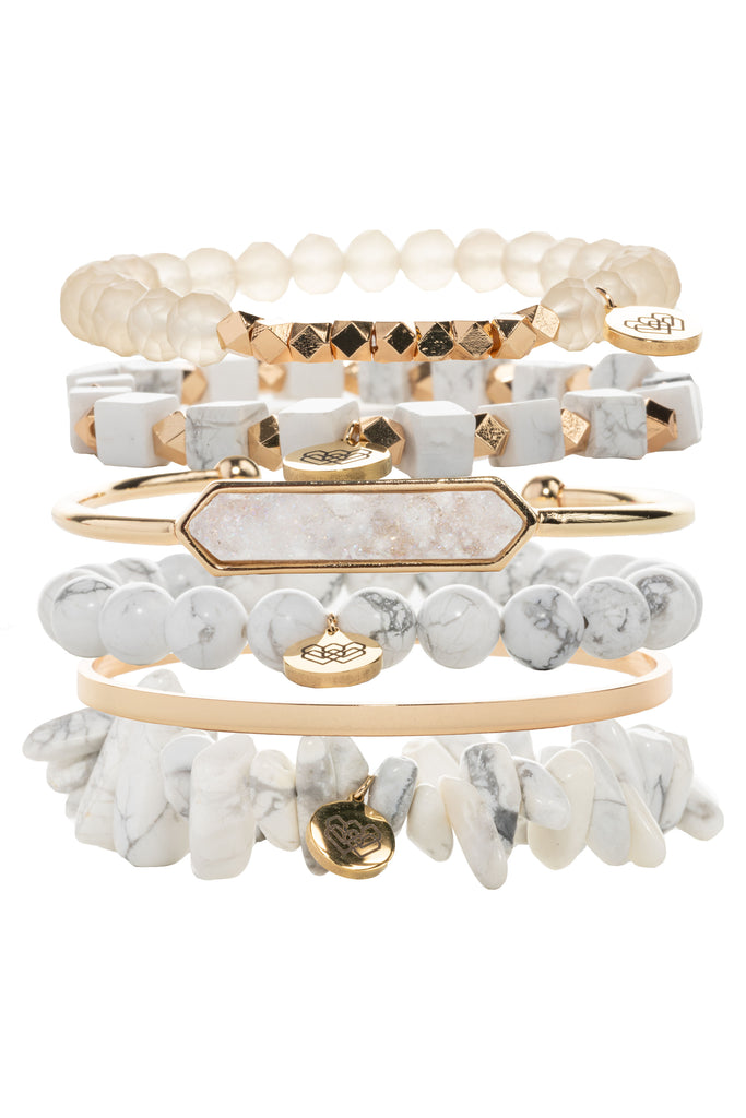 This 6 piece Moment of Patience crystal intention set is made from exquisite marbled crystal and howlite, accented with gold tones, druzy quartz, and opaque glass beads. 