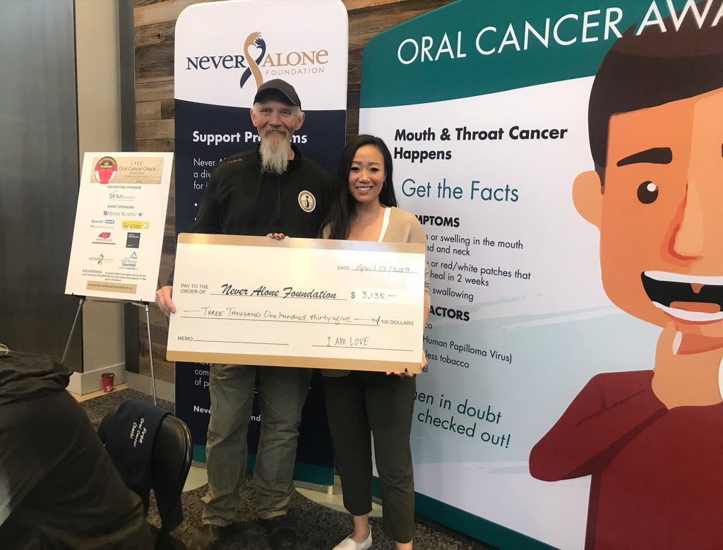 Amy Tung presents donation cheque to Never Alone Foundation with Lyle Bauer