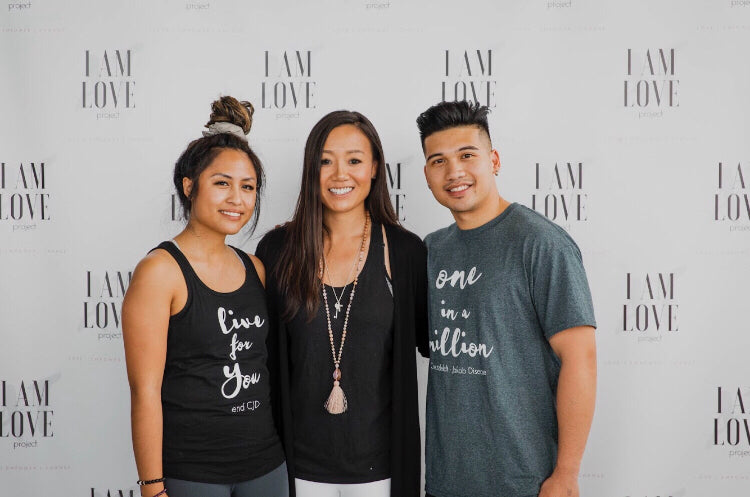 Two Asian females and Asian male standing infront of an I AM LOVE backdrop - Michelle Santos and Amy Tung