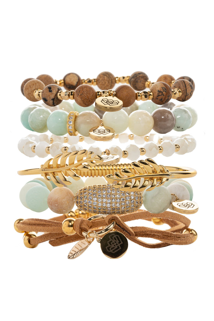 Elegant gold-toned crystal bracelet collection, featuring amazonite and picture jasper beads, bangles, and a suede wrap. 