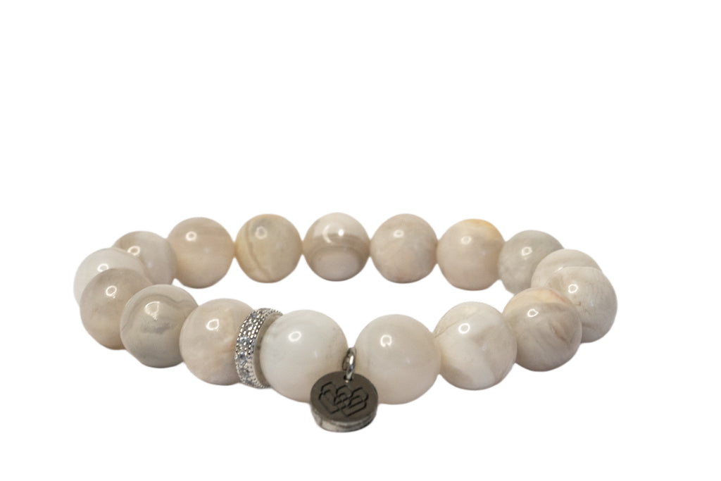 Explore our exquisite 10mm beaded crystal white lace agate bracelet featuring a pave CZ spacer and charming accent. Elevate your style with this stunning accessory, perfect for any occasion.