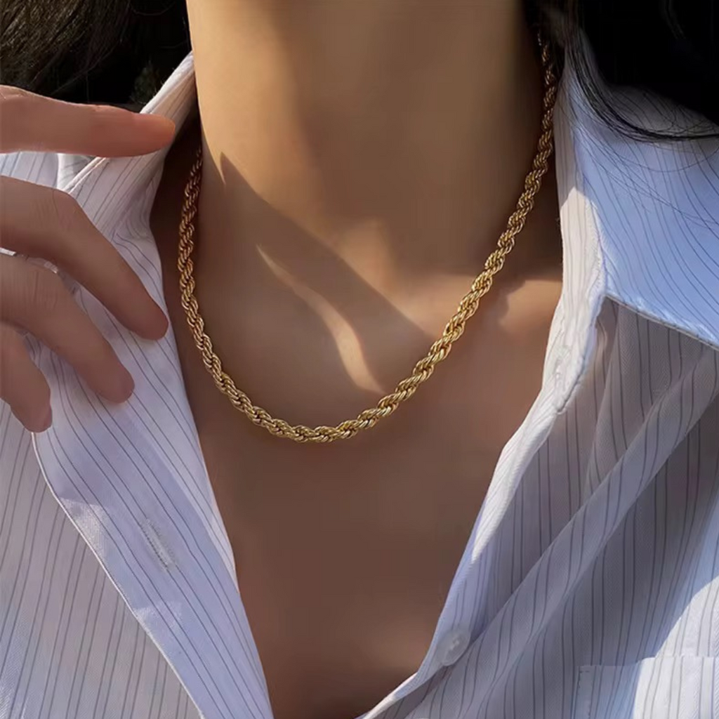 A close up of a women wearing a stainless steel 18k plated rope chain