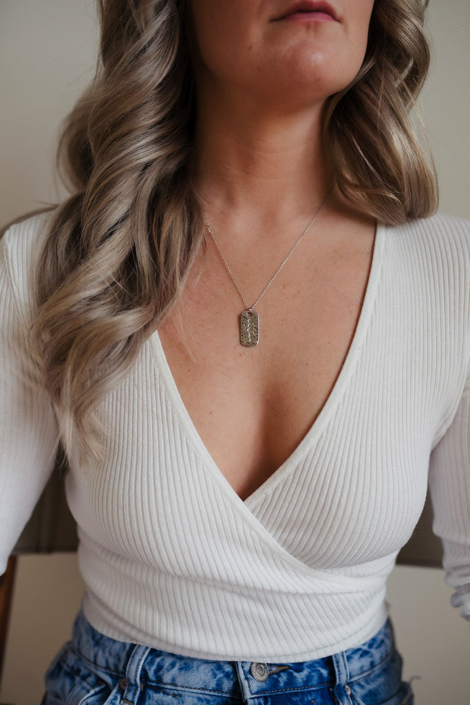 A mesmerizing 14K gold necklace featuring a hammered pendant with delicate engravings of moon phases. The pendant is adorned with a clear quartz gemstone and hangs gracefully from a dainty chain, exuding an enchanting and celestial allure.