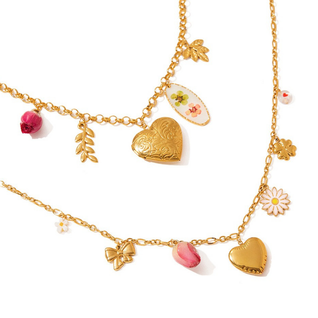 Gold charm necklaces with heart and floral charms on a white background