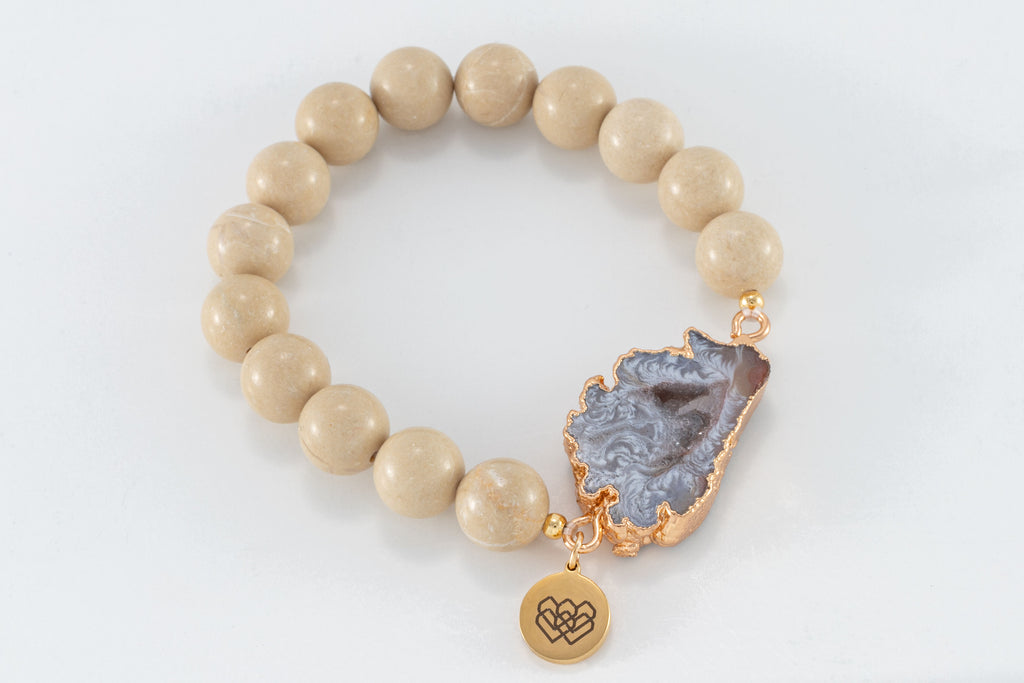 Crafted from 8mm Riverstone beads and  marbled agate stone, each piece is encased in gleaming gold details.