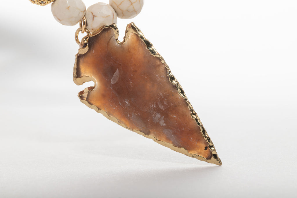 Boasting a gorgeous agate arrow centerpiece and crafted with gold accents